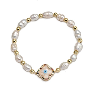 Detailed macro view of baroque pearl bracelet with gold clover evil eye pendant and gems