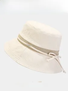 Détail d'un chapeau bob beige avec tissu texturé, étiquette LUCKY et quatre coloris
