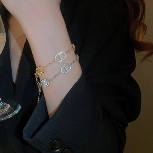 Close-up of gold and silver oval anchor link bracelets with sparkling cubic zirconia pavé