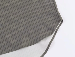 Detailed view of striped shirt featuring fine stitching and a curved hemline finish