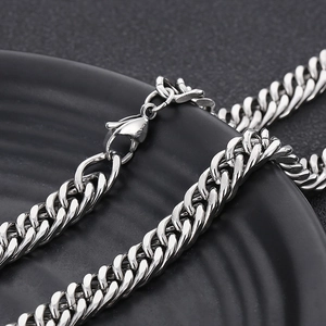 Detailed macro view of silver stainless steel curb chain with secure lobster clasp