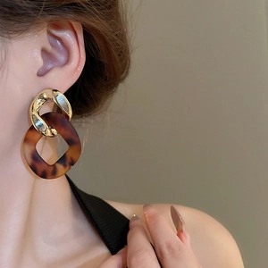 Close-up of leopard print resin chain earrings with interlocking gold metallic circles