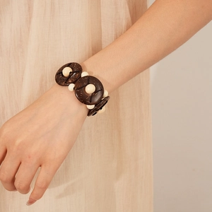 Ethnic elastic bracelet featuring coconut shell and wooden beads on a model's wrist