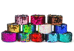 Detailed view of twelve colorful reversible sequin slap bracelets for kids