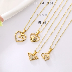 Macro view of four assorted gold-plated heart pendant necklaces with shimmering zircons