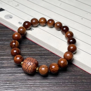 Rosewood prayer bead bracelet with carved cloud pattern bead on vintage book