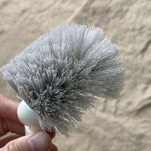 Détail des poils en nylon gris denses et de la tête ronde d'une brosse de toilette japonaise