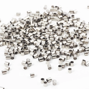 Vue macro de petits tubes à écraser en métal argenté pour la création de bijoux