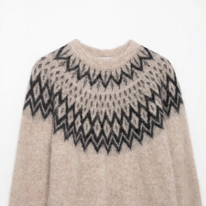 Oatmeal knit sweater with black Fair Isle jacquard pattern and fluffy alpaca texture