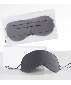 Detail of dark gray cotton sleep mask and matte storage bag with adjustable ear straps