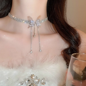 Macro shot of butterfly rhinestone choker with dangling tassels on woman's neck