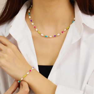 Detail of colorful beads and white pearls set for necklace and bracelet on model