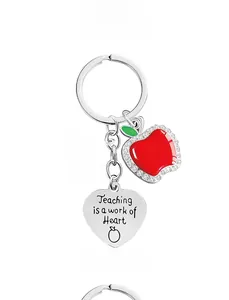 Macro detail of silver teacher gift keychain with red apple and heart charms