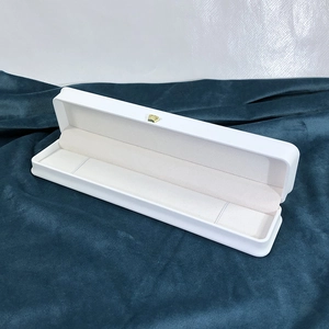Detailed view of white PU leather jewelry box featuring a golden crown logo and beige lining