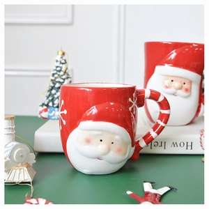 Ceramic Santa Claus 3D embossed mug with striped handle on festive Christmas table