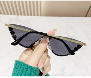 Close-up of cat-eye sunglasses with gold metal frame and black bead lens edges