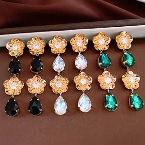 Vue détaillée de boucles d'oreilles fleurs en or 18K avec de longs glands en trois couleurs
