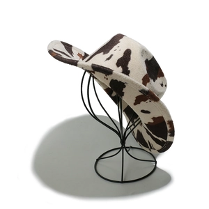 Detail of cow print western cowboy hat with brown and black patterns on white felt fabric