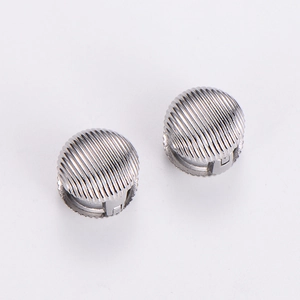 Macro detail of silver spherical clip-on earrings with polished vertical striped texture