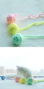 Close-up of macaron colored yarn cat toy with long tail used by a white kitten