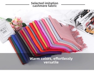 Macro shot of assorted colorful cashmere-like scarves with fringe details on a table