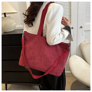Detail of burgundy corduroy tote bag featuring adjustable strap and soft vintage texture
