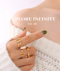 Close-up of golden U-shaped wave ring and heart arrow open ring worn by model