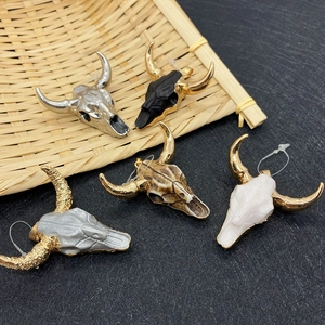 Bohemian bull head pendants in five vintage finishes on a rustic textured background