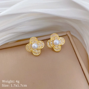 Detailed close-up of floral pearl earrings with gold base and zircon petals