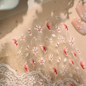 Detailed view of floral and butterfly nail art stickers on vintage lace background