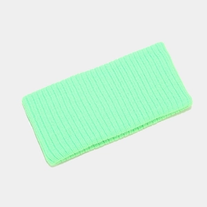 Close-up of neon green knitted sports headband featuring elastic ribbed texture