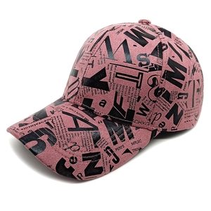 Detailed view of pink baseball cap with black newspaper letter print and curved brim