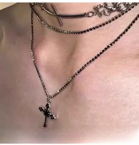 Detail of layered stainless steel necklaces with black cross pendant and crystal choker