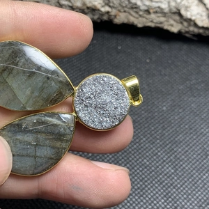 Detail of vintage labradorite pendant with golden metal frame and crystal center