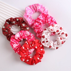 Set of six heart pattern scrunchies in red and pink colors on a clean white background