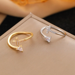 Detailed close-up of gold and silver cross rings with zircon stones on a silk display
