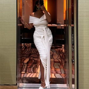 Detail of white off-shoulder maxi dress featuring ruched texture and long side streamers