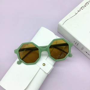 Close-up of green hexagonal kids sunglasses with UV400 lenses and white leather pouch