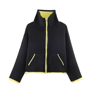Detail view of high collar jacket with neon green trim and symmetric pockets