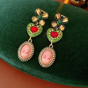 Détail de boucles d'oreilles vintage avec camée portrait et gemme de cœur rouge
