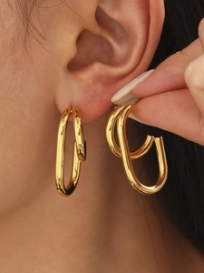 Close-up of elegant double-layered gold U-shaped hoop earrings on female model
