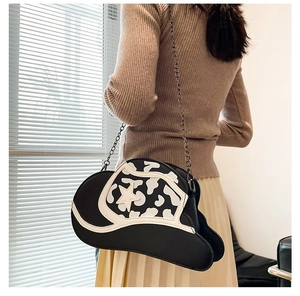 Detail of cowboy hat-shaped crossbody bag with cow print patterns and star detail