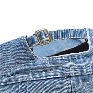Adjustable bronze buckle on washed denim newsboy cap with neat double-needle stitching
