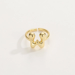 Macro detail of high-polish gold adjustable ring featuring a fluid letter W design