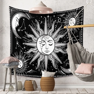 Detail of bohemian sun and moon tapestry on a grey wall in a modern living room