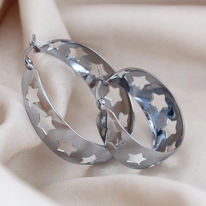 Detailed close-up of chunky silver hoop earrings featuring hollow star patterns
