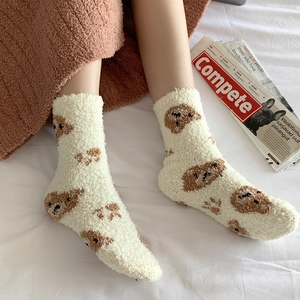 Detailed texture of thick coral fleece socks with cute brown bear patterns for winter