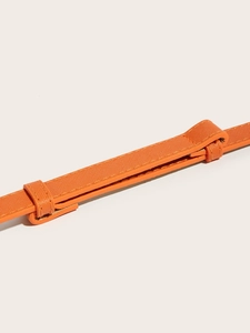 Close-up of orange Saffiano leather belt texture with stitching and buckle detail