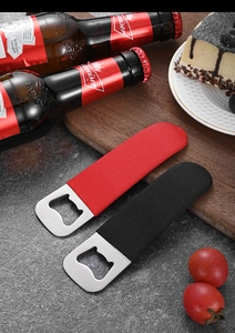 Detail of red and black PVC coated stainless steel bottle openers on a kitchen counter