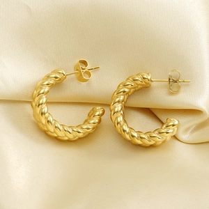 Exaggerated 18k gold plated stainless steel twisted rope hoop earrings on silk background